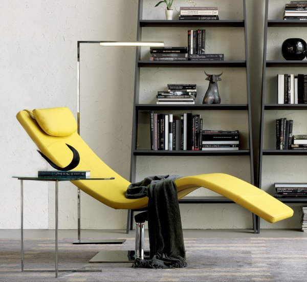 Angolo lettura con chaise longue, tavolino, lampada, libreria