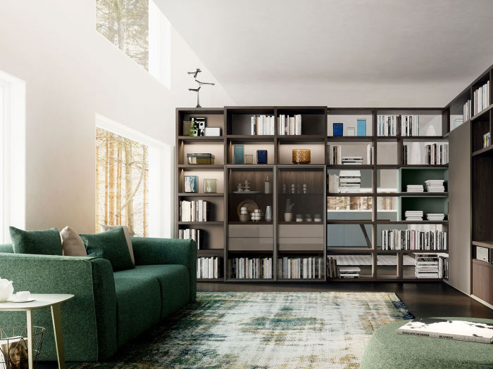 Angolo lettura con divano di design e libreria separa ambienti