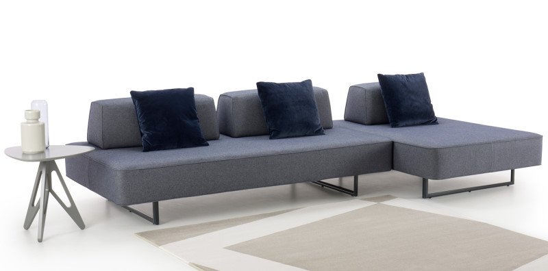 Divano design minimal in tessuto blu con piedi a slitta in metallo