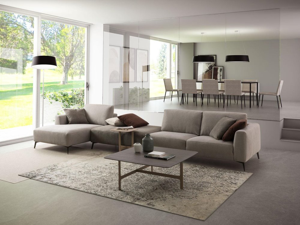 Luminoso soggiorno con divano componibile grigio tortora