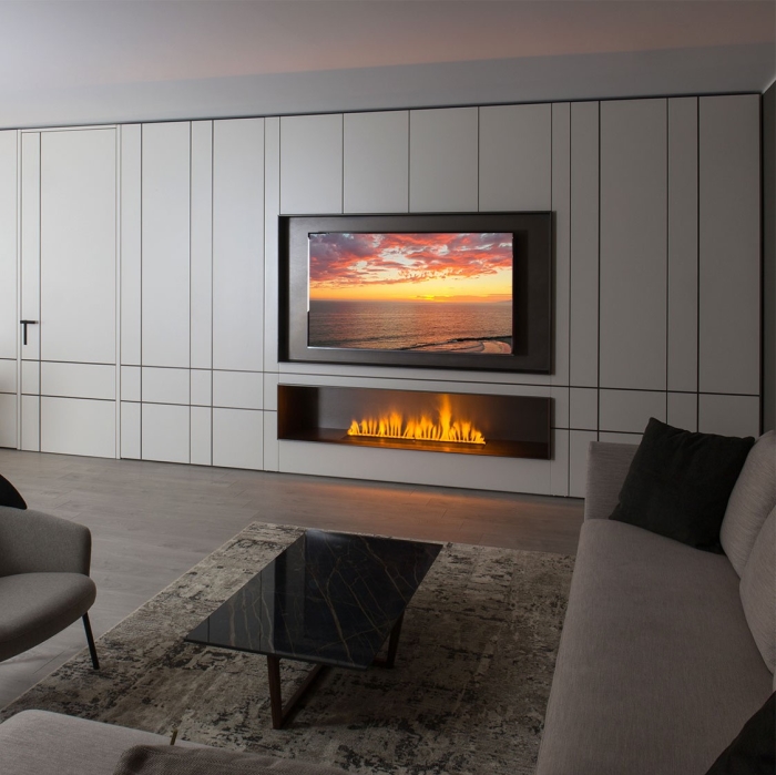 Salotto con parete Lounge decorata con inserti in metallo, vano TV e caminetto a vapore
